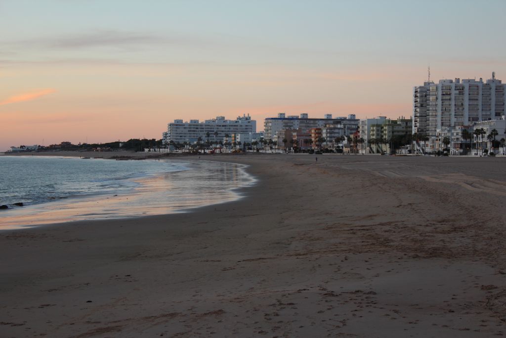 Atardecer en la playa de Rota con edificios blancos al fondo